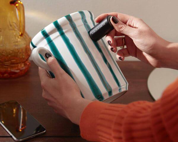 Hand-held cabinetry colour matching device scanning a patterned mug.